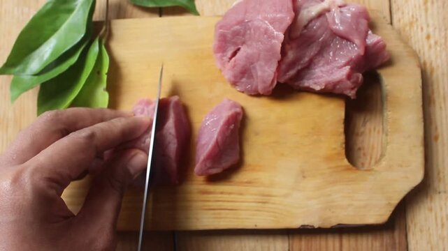 top view of slicing raw beef on a chopping board