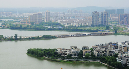 Aerial View of Modern Riverside City Development with Lake and Bridge © TranPhuoc