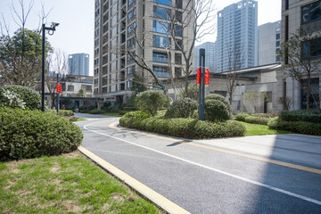 Modern residential area with landscaped roads, greenery, and high-rise buildings under clear sky © zhu difeng