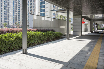 Modern urban commercial area corridor with greenery, high-rise buildings and clean architectural elements © zhu difeng