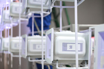 Powder coating workshop with microwave oven casings on overhead conveyor system in operation