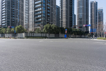 Empty urban intersection with modern high-rise buildings and clear daytime sky © zhu difeng