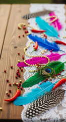 Fototapeta premium Vibrant decor for Cinco de Mayo celebration featuring colorful feathers, spicy peppers, and golden beads on a rustic wooden table