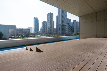 Modern architectural terrace with wooden flooring overlooking urban skyline and high-rise buildings © zhu difeng