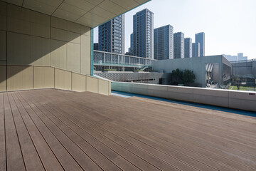 Modern architectural terrace with wooden flooring overlooking urban skyline and high-rise buildings © zhu difeng