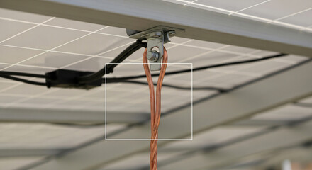 Obraz premium Close-Up View of Copper Grounding Wire and Metal Lug Attached to the Aluminum Frame of a Solar Panel Array Installation