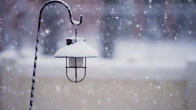 View of lamp as large snowflakes fall in slow motion during storm in Utah.