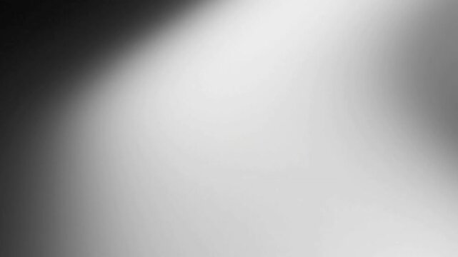 Subtle Light Transition A static shot focusing on the gentle, continuous movement of light and shadow creating a neutral duotone effect on a smooth, undefined surface.