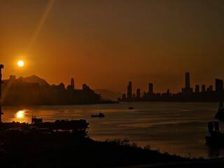 Fototapeta premium A dramatic sunrise illuminates a towering cityscape reflected in a