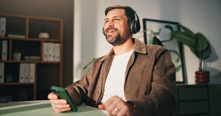 Headphones, phone or happy man with break in home office, music listening or podcast for remote work. Mobile, feel good playlist or freelancer with tech for streaming, radio or album for productivity
