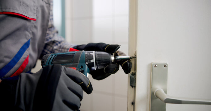 The Experienced Locksmith Expertly Replacing A Damaged Door