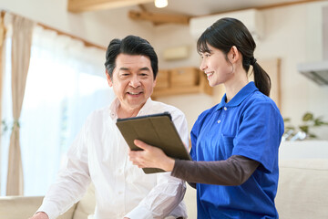 訪問介護でタブレットで管理をする介護士