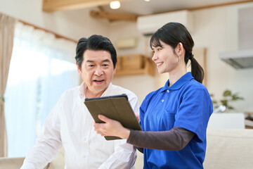 訪問介護でタブレットで管理をする介護士