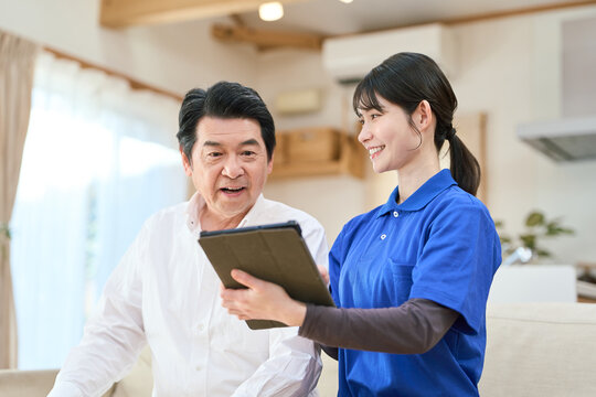 訪問介護でタブレットで管理をする介護士