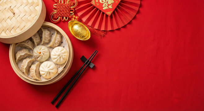 Steamed dumplings in bamboo steamer with chopsticks and red chinese new year decorations on red background
