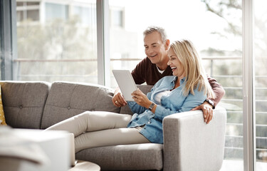 Obraz premium Tablet, laugh and couple in living room for social media, video and bonding on home sofa. Technology, smile and mature man with woman and subscription for streaming, movie or internet browsing