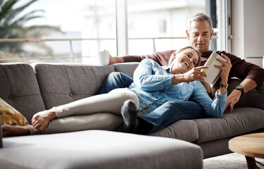 Obraz premium Book, reading and love with mature couple on sofa with smile, bonding and living room of home together. Literature, rest and storytelling with happy man, woman or conversation in house with novel