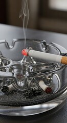Obraz premium Cigarette in an ashtray with smoke.
