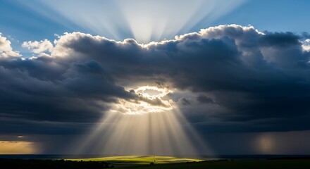 Dramatic sky with sun rays piercing through clouds over landscape