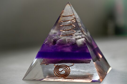High resolution color image of a Large Handmade Orgonite Pyramid with Amethyst Crystals &ndash; Symmetrical Copper Design on White Marble Background