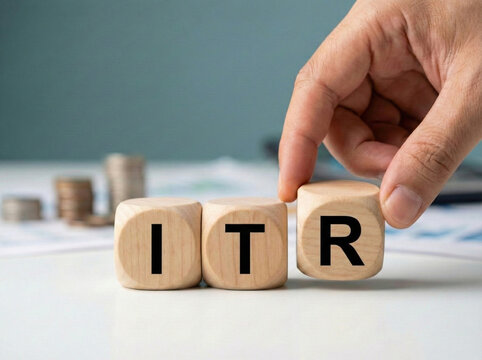 hand placing itr wooden cube blocks on desk representing income tax return filing accounting compliance and business taxation concept
