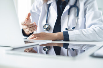 Telemedicine concept. Female doctor giving online consultation to patient via laptop computer at...