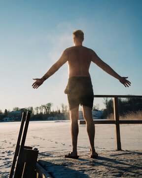 man standing in minus temperatures by a floating sauna