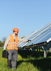 Technician walking and installing solar panels in solar farm © Serhii