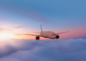 Fototapeta premium Airplane flying over tropical sea at sunset