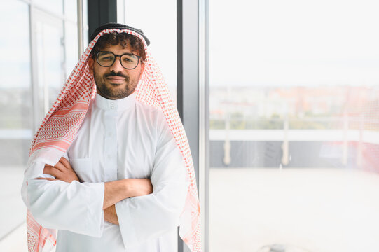 Successful arab businessman wearing traditional kandura posing with crossed arms