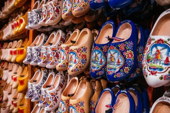 Rows of hand-painted wooden clogs reflecting dutch heritage, displayed in a colorful shop as popular traditional souvenirs for tourists visiting holland and the netherlands