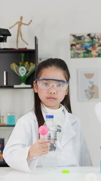 Young Asian Girl Performing Bernoulli's Principle Science Experiment with Ping Pong Ball