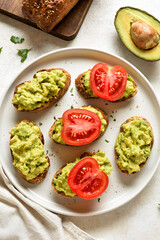 Bruschetta with mashed avocado and tomato slices