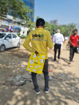Delivery rider from indian quick commerce hyperlocal delivery startup blinkit standing outside a dark store with package