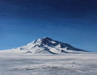 Snow-capped mountain amidst snowy expanse under a deep blue sky