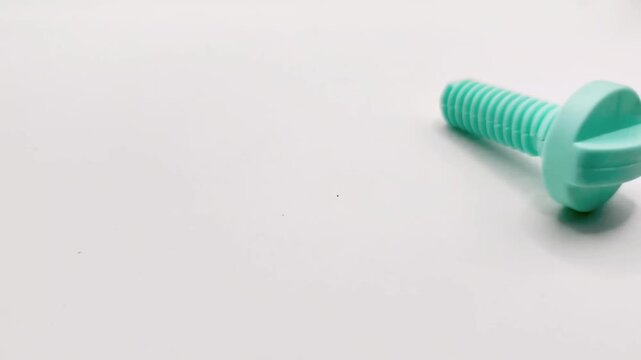 blue plastic bolts rolling on a white background. children workbench or construction playset