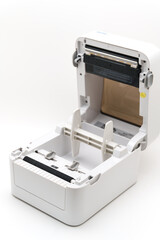 Small printer sits open on a white surface with paper inside