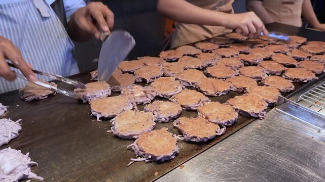 Pan crackles, aroma rises, street rhythm sings in coconut delight called Kanom Babin