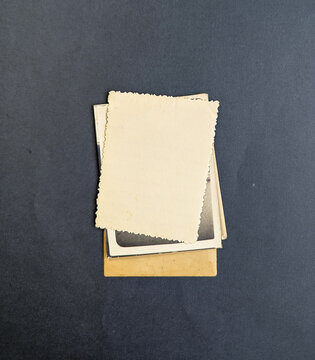 Stack of old photos isolated on dark background. Mock-up blank paper. Vintage old paper collection with place for text of photo frame