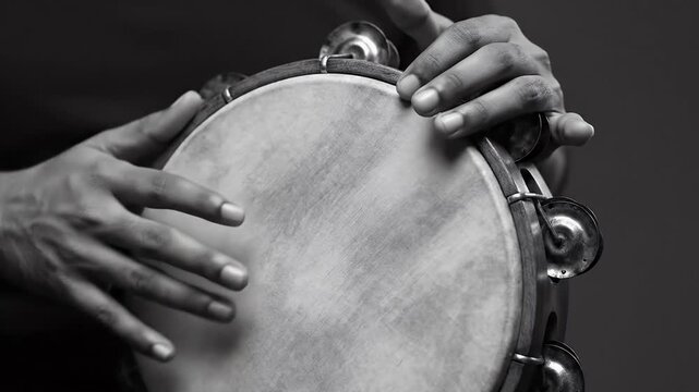 Close Up of Dark Skinned Hands Playing Tambourine in a Black and White Composition