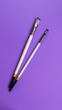 White Wooden Synthetic Paintbrush isolated on Violet Background