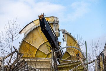 Collapsed industrial structure with torn metal panels outdoors.