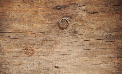 Texture of an old wooden board with cracks and a knot.
