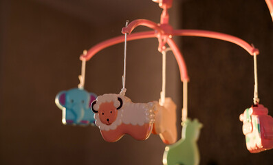 pink baby nursery mobile featuring cute hanging animal toys © jozzeppe777