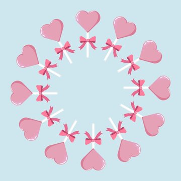 Circular wreath of pink heart-shaped lollipops with bows, evenly spaced on pastel blue background