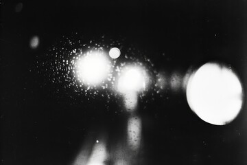 Black and white blurry film negative with glowing lights grain texture vintage abstract background