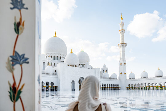 Tourist admiring sheikh zayed grand mosque in abu dhabi, united arab emirates