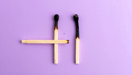 Burnt matches on purple background forming smiley face