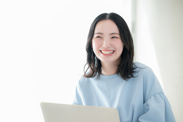 A stylish woman working, searching, or researching on her computer in a bright room A positive, forward-thinking image of skill development and career advancement through qualifications and study