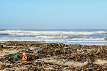 Plastic and wood waste after a storm polluting the beach